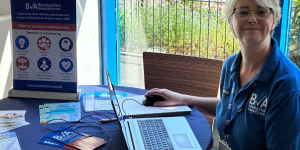 BVA staff member sitting at table smiling during a Community Volunteer Hub