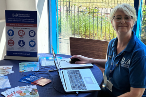 BVA staff member sitting at table smiling during a Community Volunteer Hub
