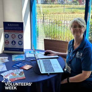 BVA staff member sitting at table smiling during a Community Volunteer Hub